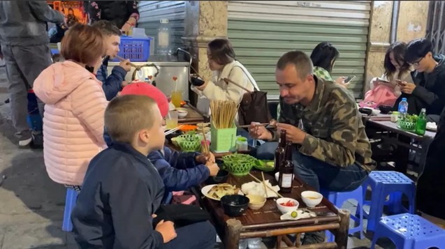 Our family eating street food together in Hanoi